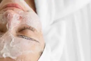 Woman receiving exfoliating signature facial mask at Aesthetic Studio in St. Augustine, FL