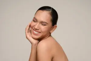 Woman with radiant skin smiling after dermaplaning facial at Aesthetic Studio in St. Augustine, Florida
