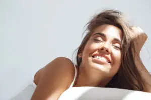 Woman with smooth glowing skin relaxing after dermaplaning facial at Aesthetic Studio in St. Augustine, FL